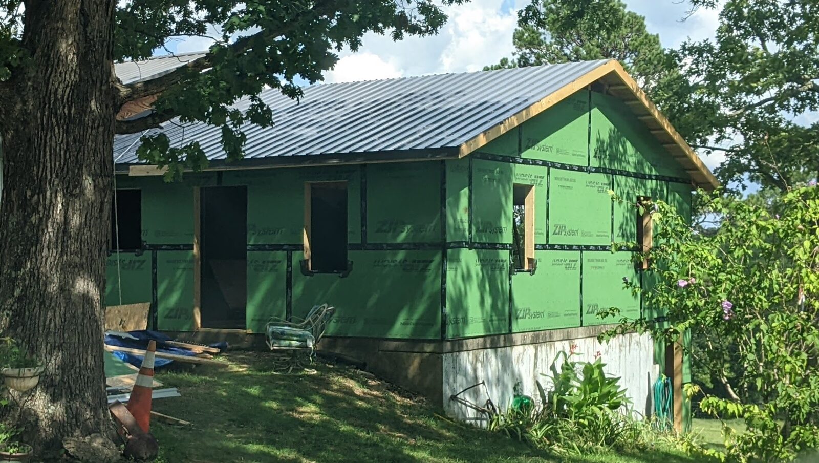 Single-story house with metal roof installed and ZIP sheathing complete