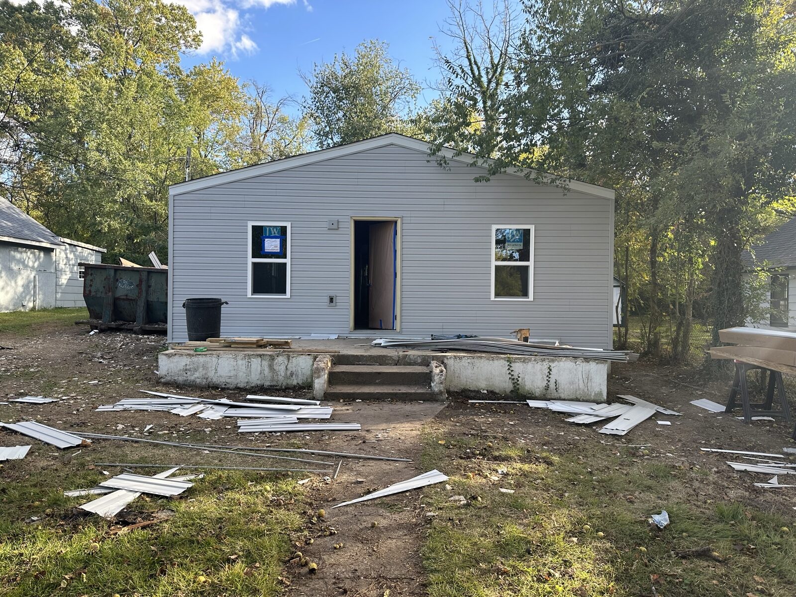 Completed small single-family home with light gray vinyl siding