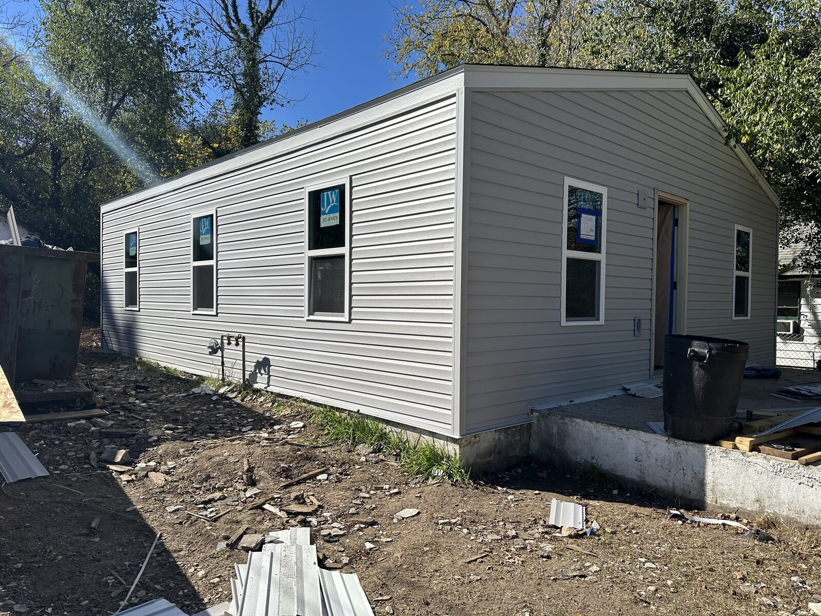 Completed small cottage with light gray siding and white trim