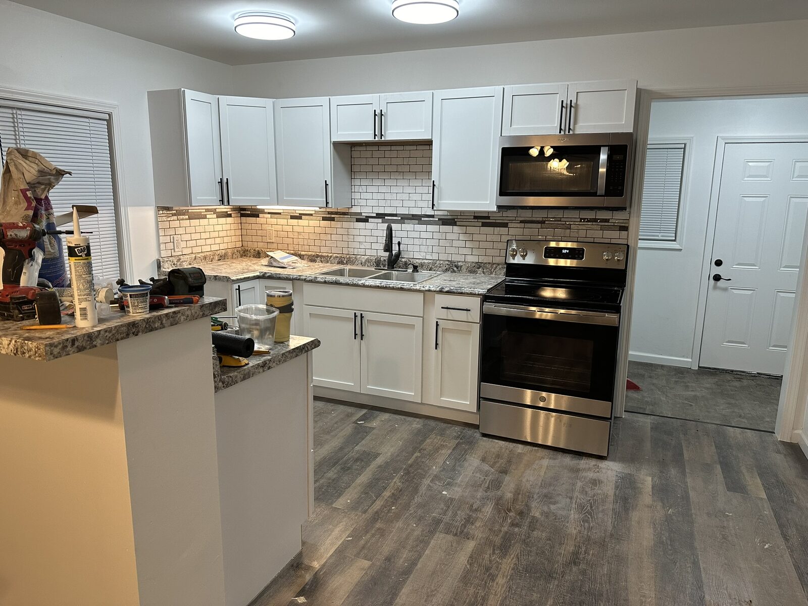 White shaker kitchen with subway tile backsplash and stainless appliances in a recent McDonald and Sons build