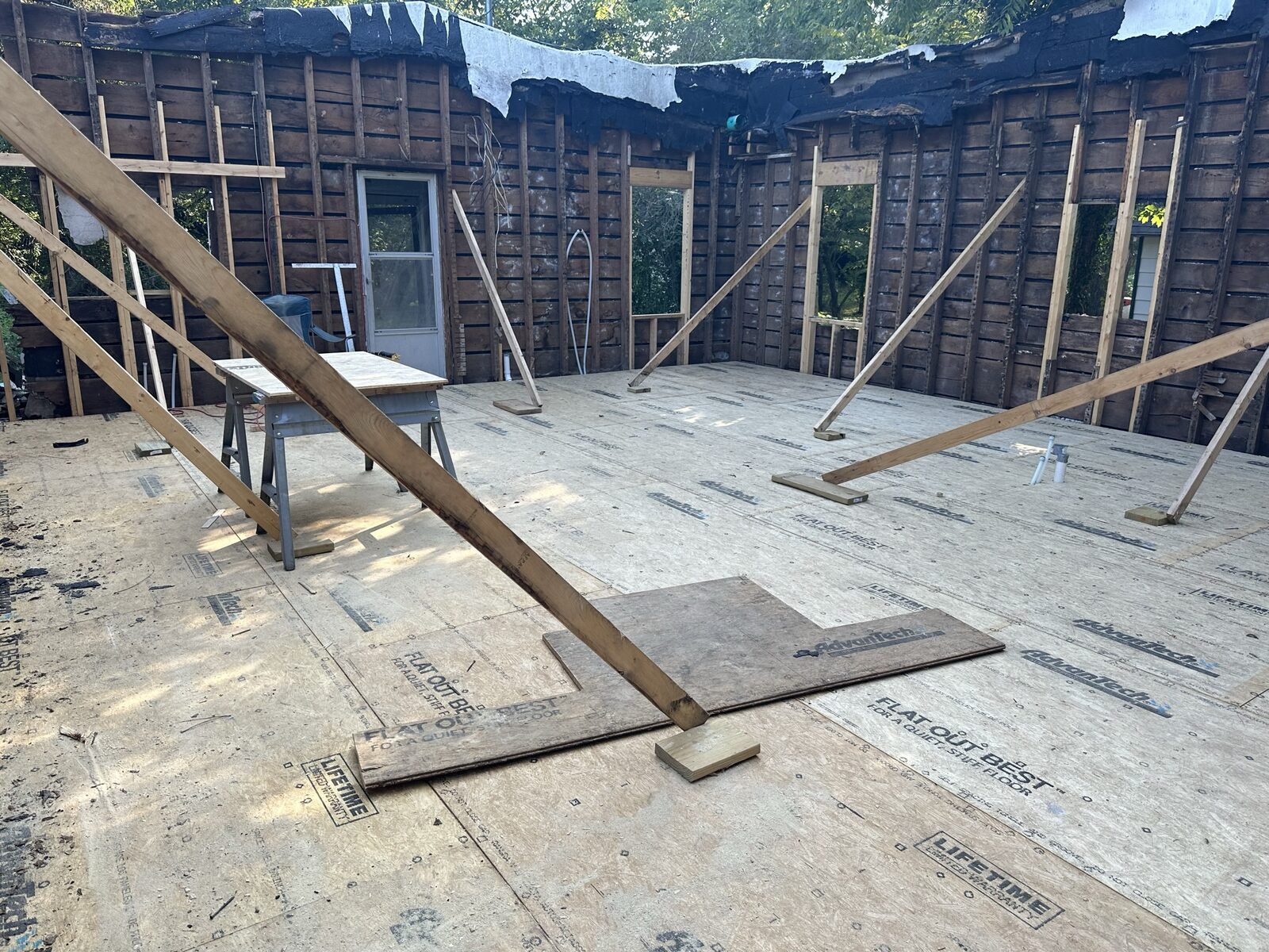 Older home stripped to the studs with floor joists exposed during a major restoration
